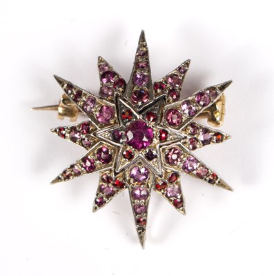 Lot 118 - A ruby starburst brooch/pendant, with...