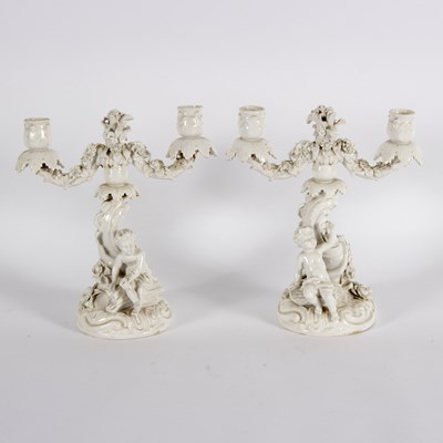 Lot 233 - A pair of porcelain two-branch candlesticks,...