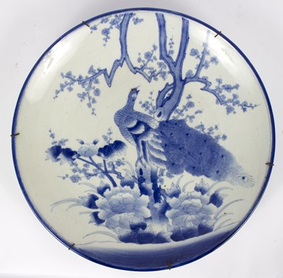 Lot 293 - A Japanese blue and white charger decorated a...