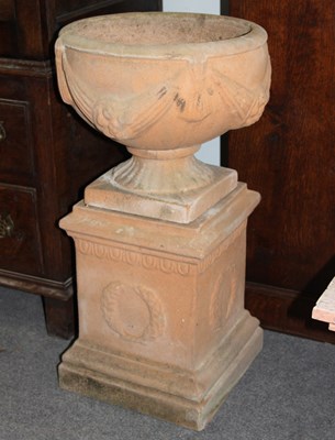 Lot 626 - A simulated terracotta urn with swag...