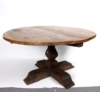 Lot 849 - A circular oak table on square baluster column...