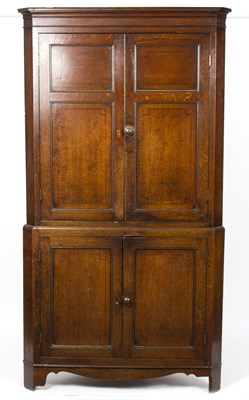 Lot 874 - A George III oak floor standing corner...