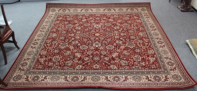 Lot 940 - A machine made floral carpet with red ground...