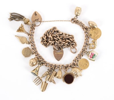 Lot 93 - A 9ct gold charm bracelet hung with a variety...