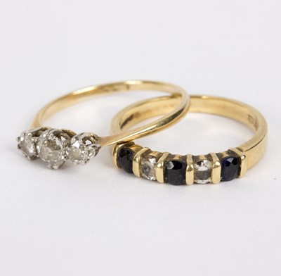 Lot 110 - A diamond three-stone ring to a yellow gold...