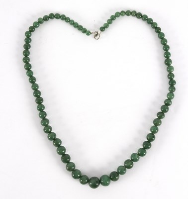 Lot 247 - A single row of graduated jade beads, 73cm long