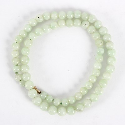 Lot 306 - A single row of celadon jade beads, 48.5cm long