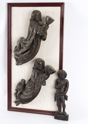 Lot 374 - An oak carving of a putti holding a...