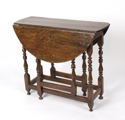 Lot 566 - An 18th Century oak gateleg table, on turned...