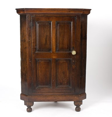 Lot 627 - An oak corner cabinet with panelled door, on...