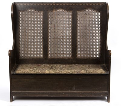 Lot 794 - A box settle, with cane back and wing arms,...