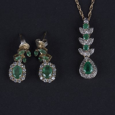 Lot 157 - A diamond and emerald pendant, the pear drop...