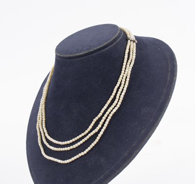 Lot 207 - A three-row seed pearl necklace, the strands...