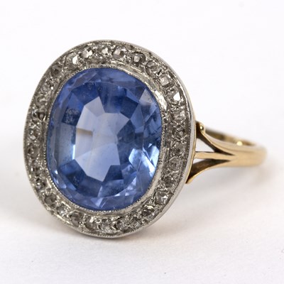 Lot 243 - A sapphire and diamond cluster ring, the oval...