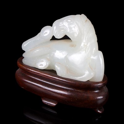 Lot 366 - A white jade carving of a recumbent horse,...