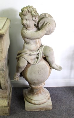 Lot 792 - A reconstituted stone putto playing the...