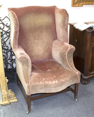 Lot 832 - An 18th Century wing back armchair, on square...