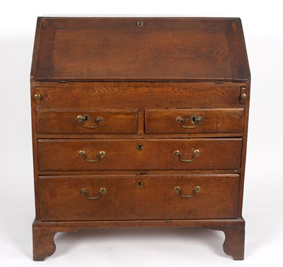 Lot 982 - A George III oak bureau, the fall enclosing a...