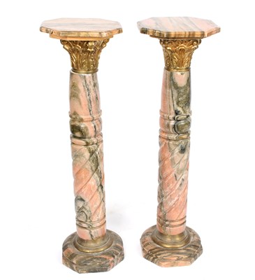 Lot 1000 - A pair of mottled stone pillars, each with...