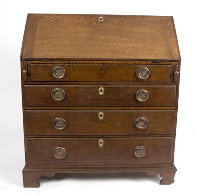 Lot 1024 - A George III oak bureau with four drawers...