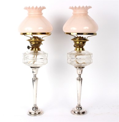 Lot 61 - A pair of silver oil lamps, each mounted on a...