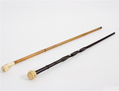 Lot 503 - Two ebonised walking sticks, both with carved...