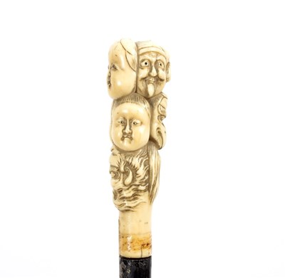 Lot 504 - An ebonised walking stick, the Japanese carved...