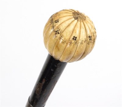Lot 517 - An ebonised walking stick, the ribbed ivory...