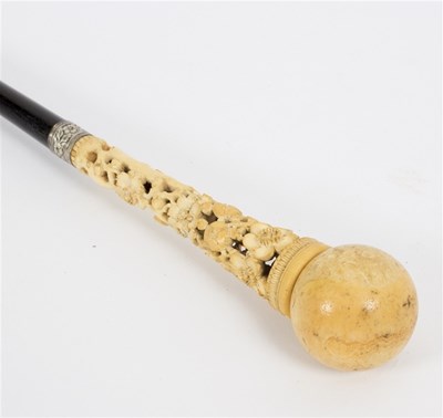 Lot 518 - An ebonised walking stick, the ivory ball...