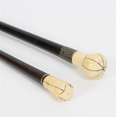 Lot 525 - An ebonised walking stick with sectional ivory...