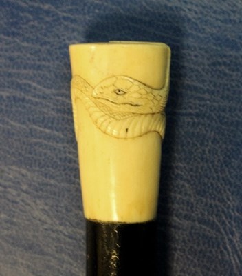 Lot 527 - An ebonised walking stick with carved ivory...