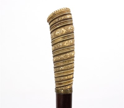 Lot 528 - A walking stick with engraved and ribbed ivory...