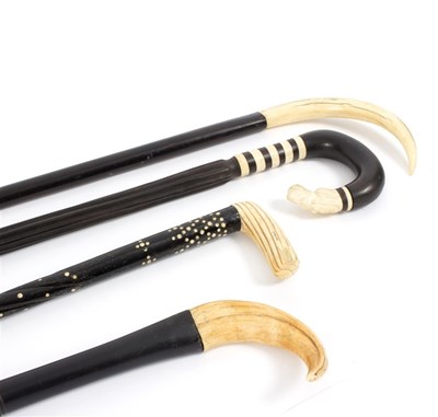 Lot 532 - Four tribal ebonised walking sticks with horn...