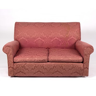Lot 875 - An upholstered two-seater sofa covered in pink...