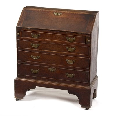 Lot 886 - A small oak bureau with four drawers on...