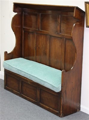 Lot 929 - An elm settle with hooded canopy, panel back...