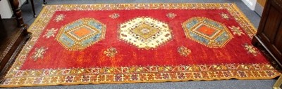 Lot 1047 - A 20th Century Moroccan red ground carpet,...