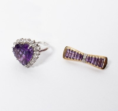 Lot 26 - A diamond and amethyst bow brooch set in...