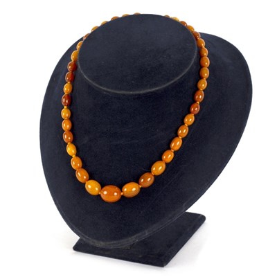 Lot 28 - An amber bead necklace of thirty-nine...