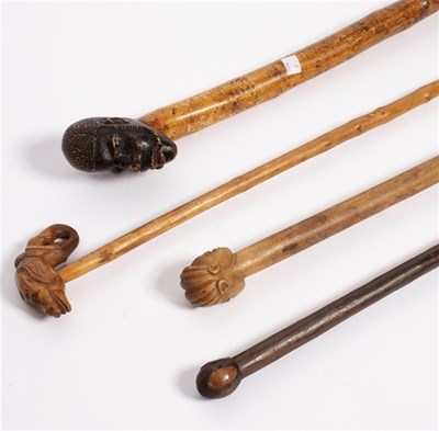 Lot 202 - A walking stick, the carved wooden handle...