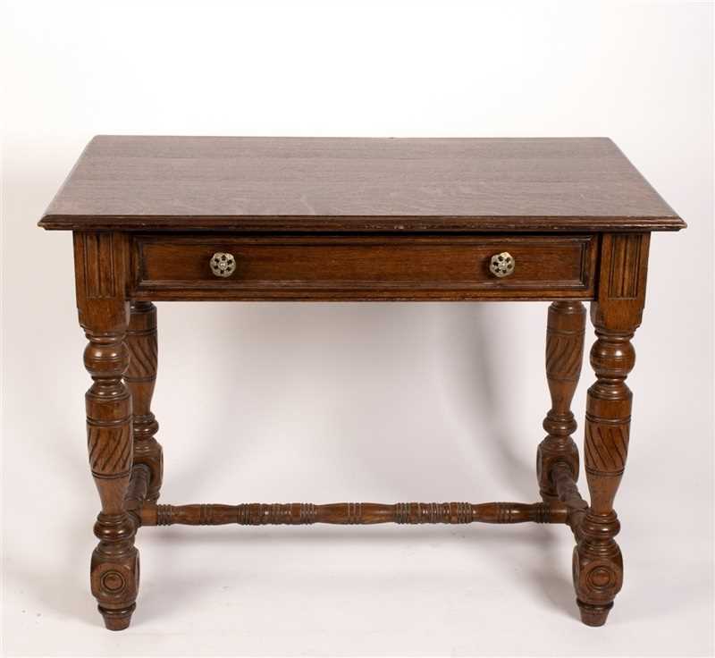 Lot 491 - An oak table fitted a drawer on carved legs...