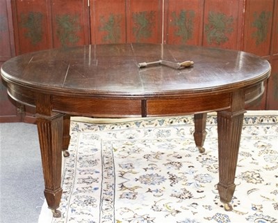 Lot 605 - An Edwardian oak dining table, the oval top...