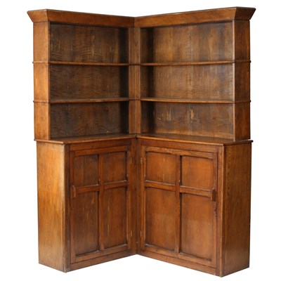 Lot 204 - A Cotswold School oak corner bookcase, the top...