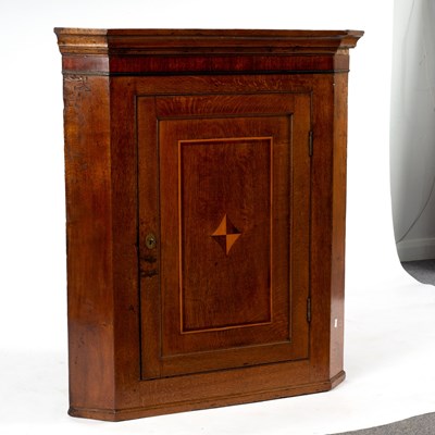 Lot 60 - An oak corner cupboard, the panelled door...