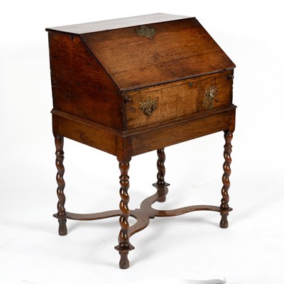 Lot 104 - An oak bureau with fitted interior on a stand...