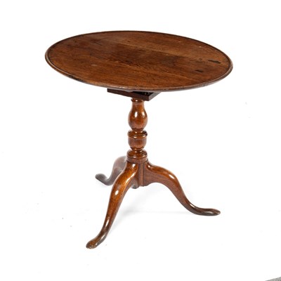 Lot 148 - A circular oak table on a turned column and...