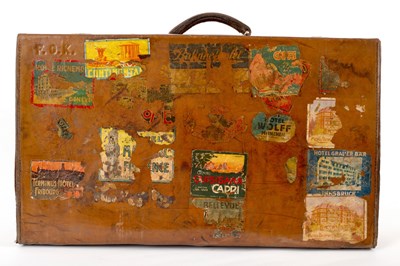 Lot 240 - A leather suitcase covered in numerous travel...