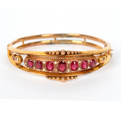 Lot 714 - An Edwardian ruby and pearl hinged bangle set...