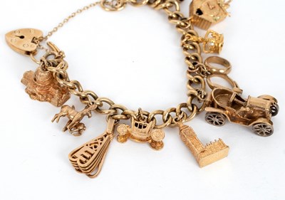 Lot 740 - A 9ct gold charm bracelet hung with 9ct gold...