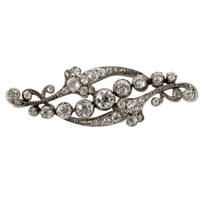 Lot 100 - A diamond brooch of scrolling form, the...